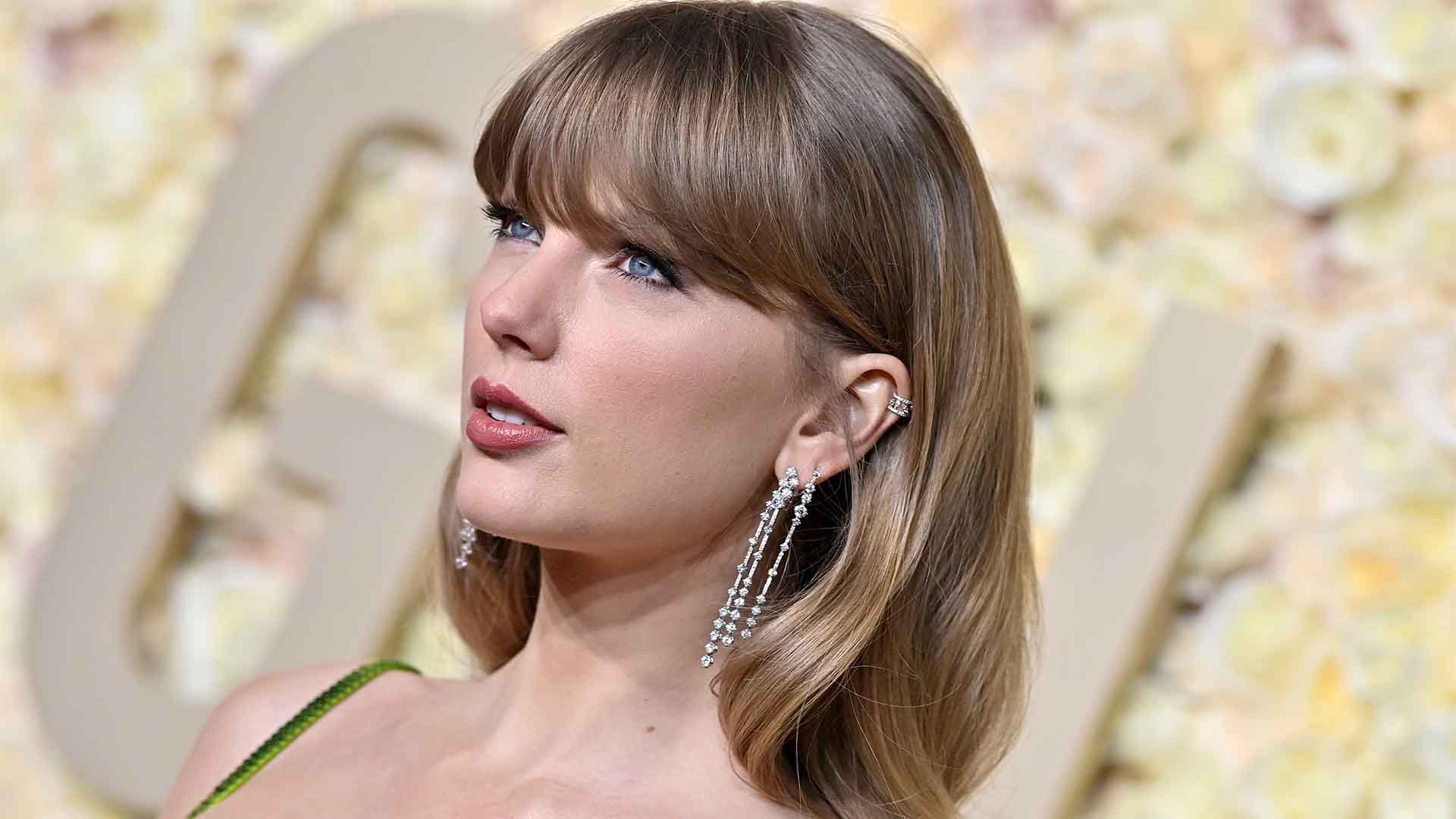 Taylor Swift poses for the camera at a red carpet event