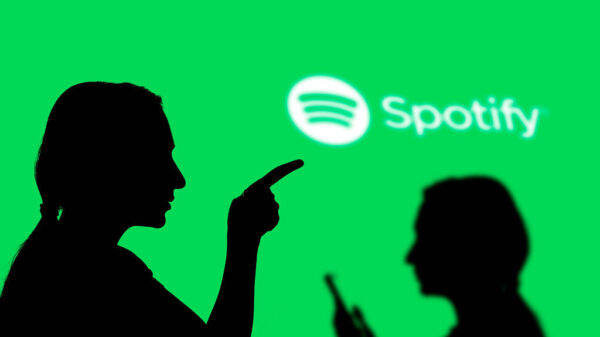 The silhouettes of two people in front of a bright green background with a Spotify logo