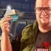A man in a vest holding up three credit cards in 'GTA 6'